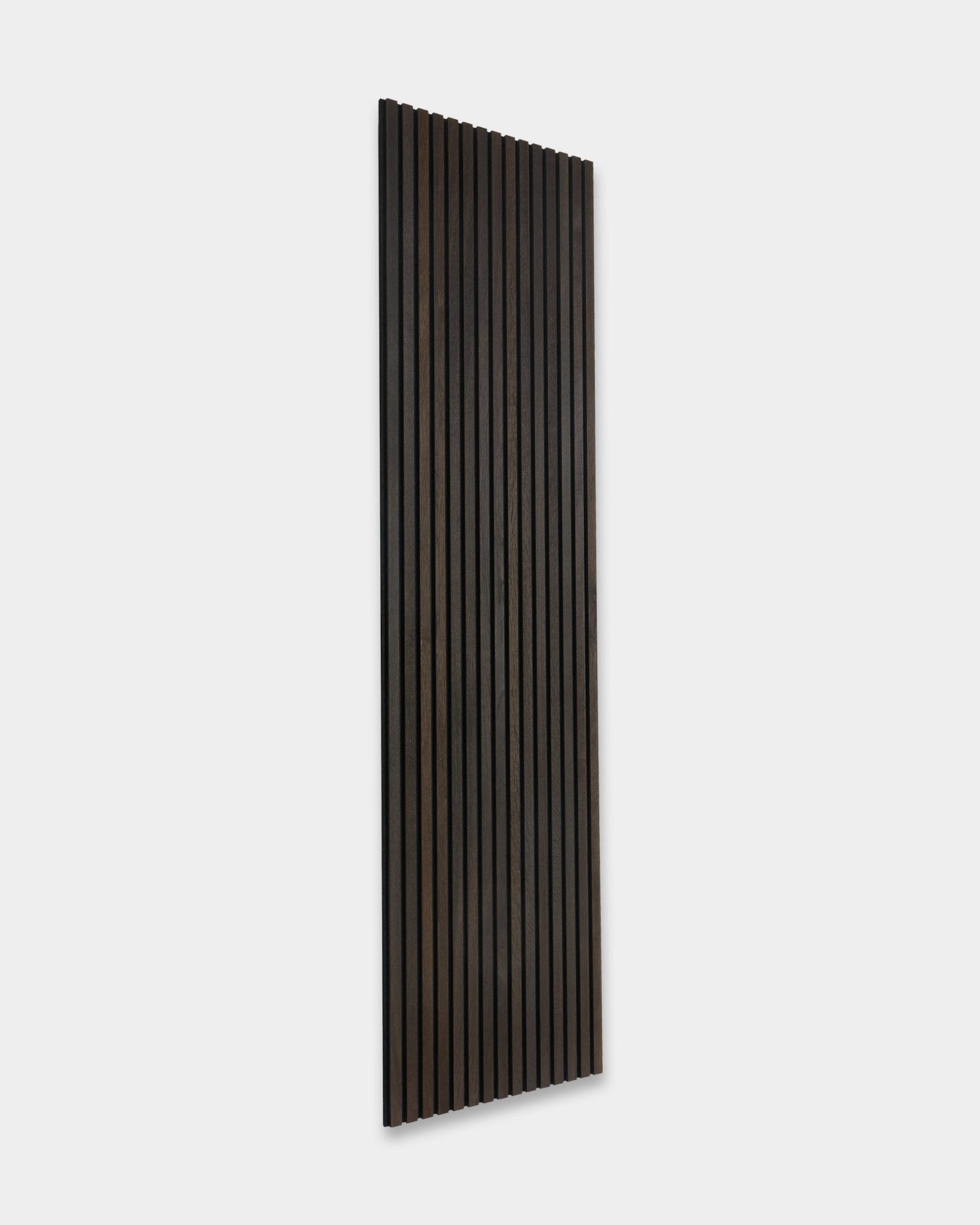 Rustic Smoked Oak Akupanel acoustic panel by WoodUpp, with vertical dark wood slats, leaning against a light gray wall.