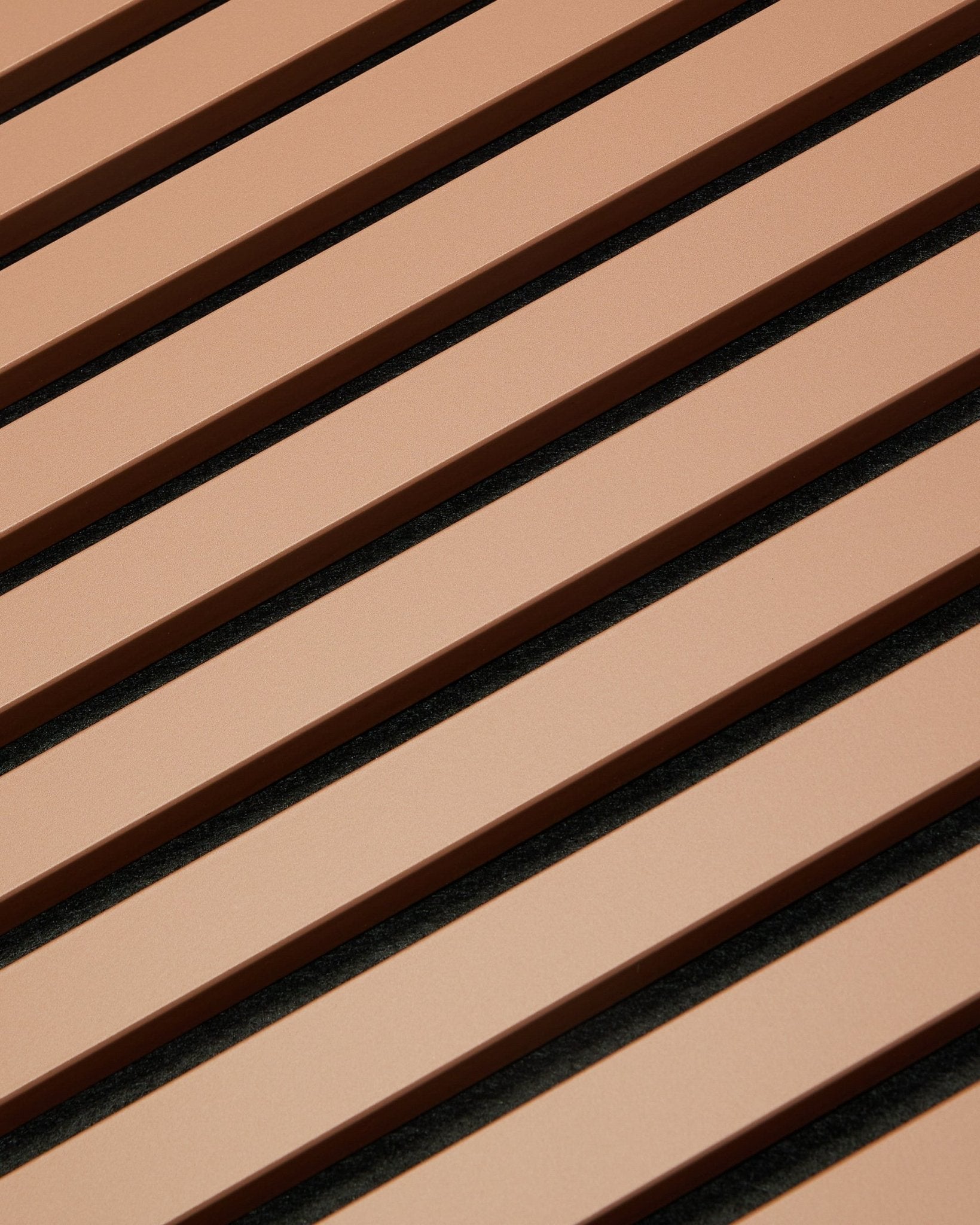 Diagonale brown og black lameller danner et stribet mønster på et 240 x 60 cm Hue | Akupanel / Clay Akustikpanel fra WoodUpp, som afspejler nordisk design.