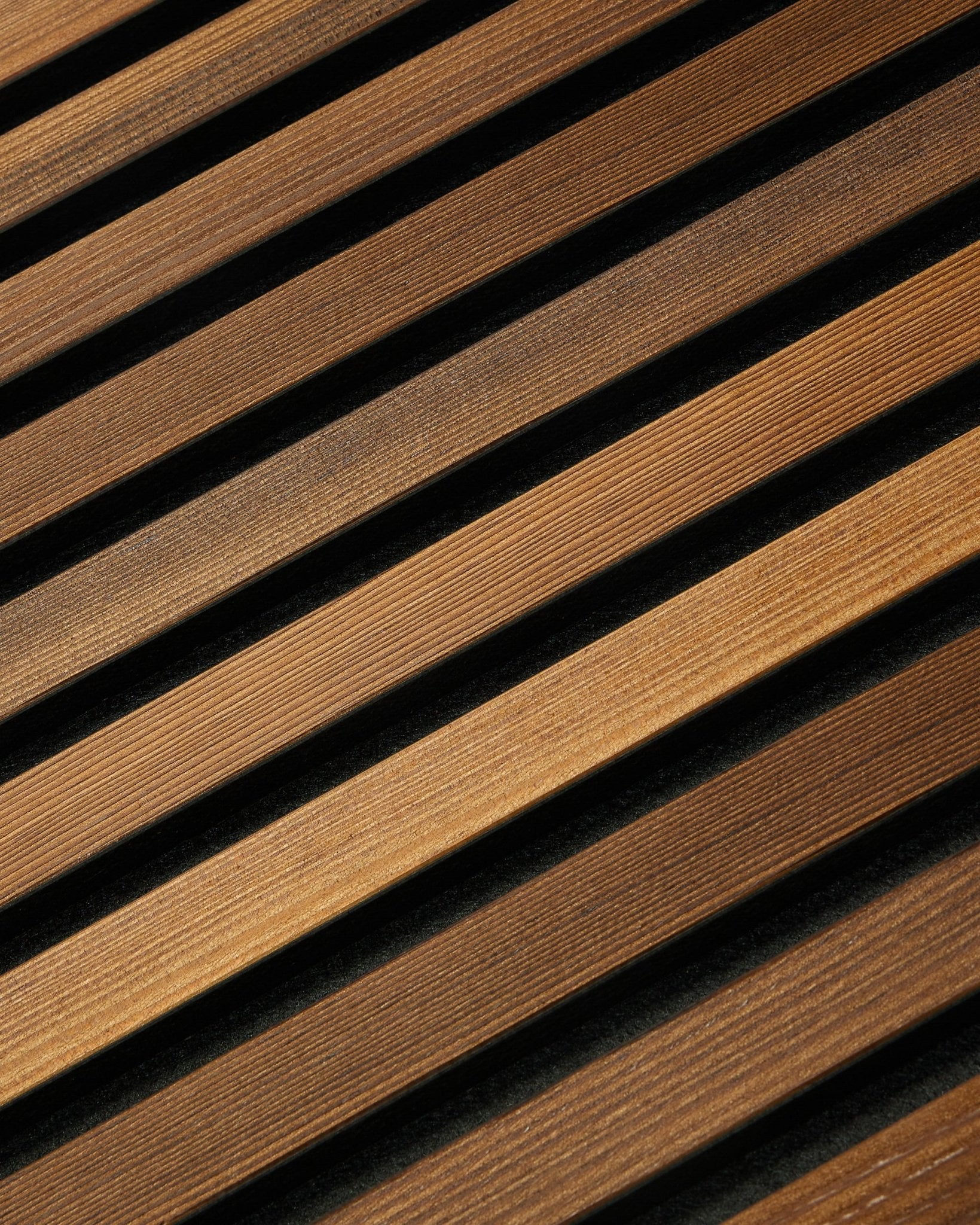 WoodUpp Akupanel Rustic i røget lærk (240x60 cm) har diagonale brown akustiklameller, der skaber et stribet nordisk udtryk med diskrete skyggedetaljer.