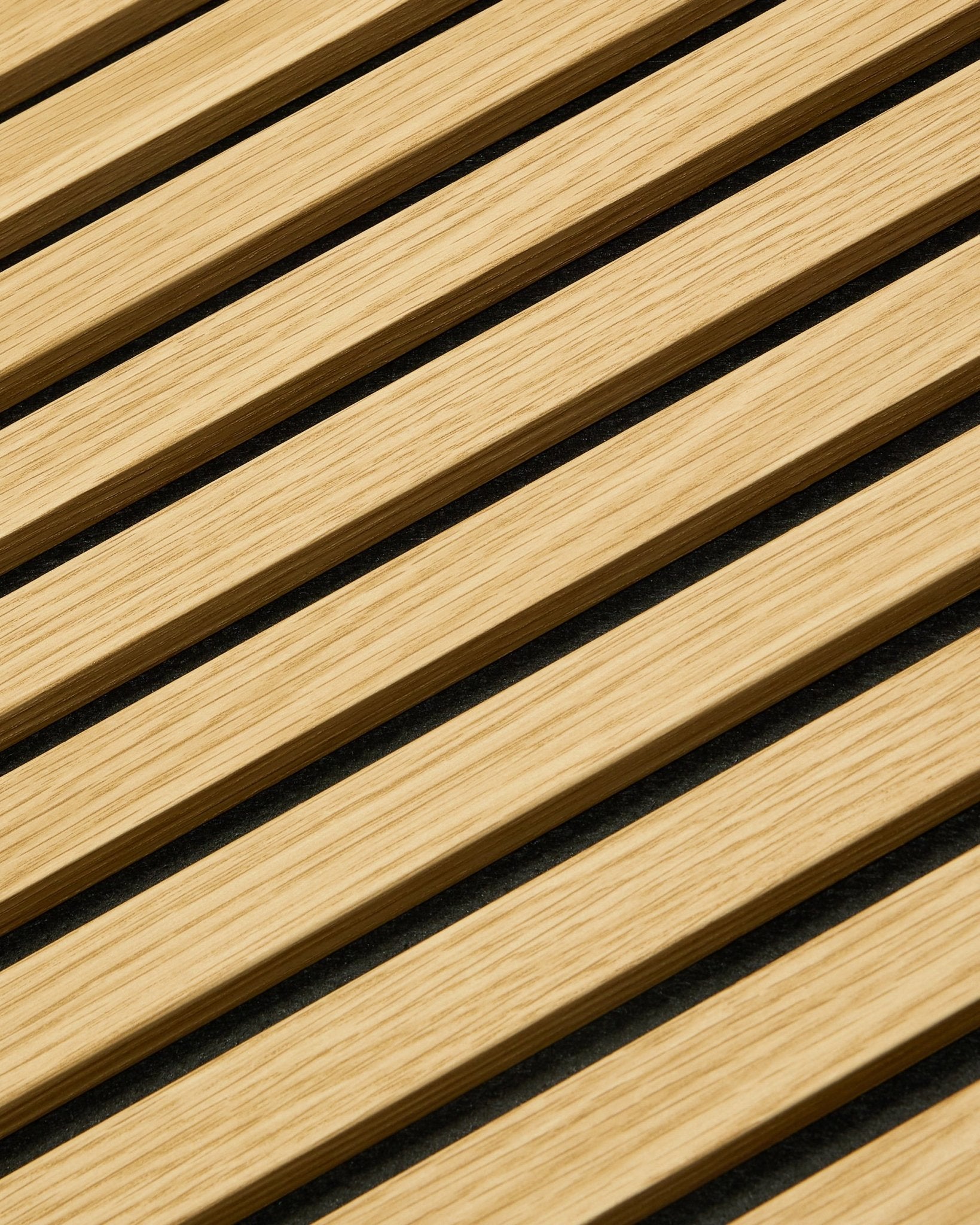 Nærbillede af WoodUpp Akupanel Akustikpanel i Southern Oak, 240x60 cm, med diagonale lameller og mørke akustiske mellemrum for bedre lydabsorption.