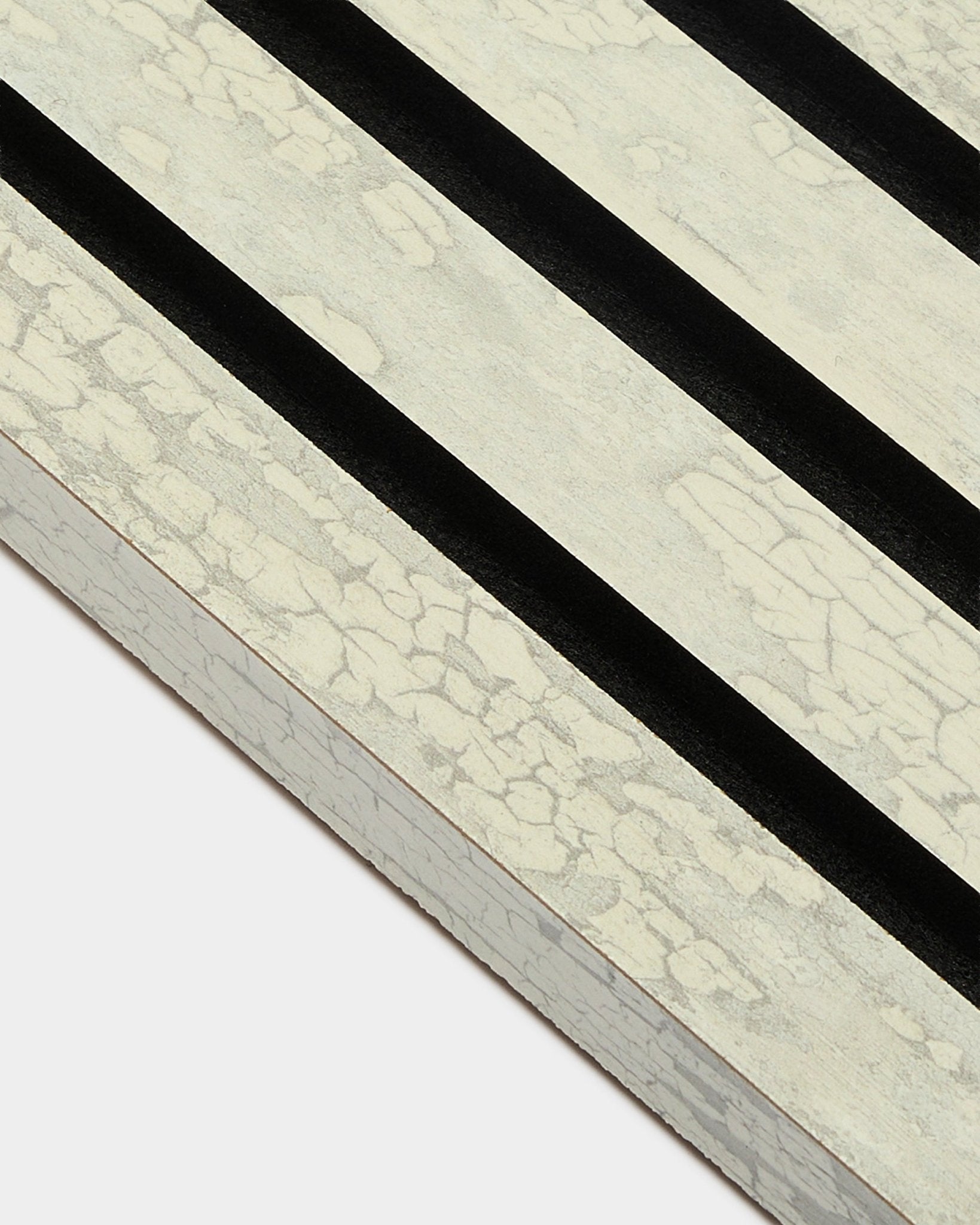 Nærbillede af WoodUpp Akupanel End Lamella i Oxide White (2,2 cm) med tre diagonale sorte striber på en ramme af MDF-akustikplader.