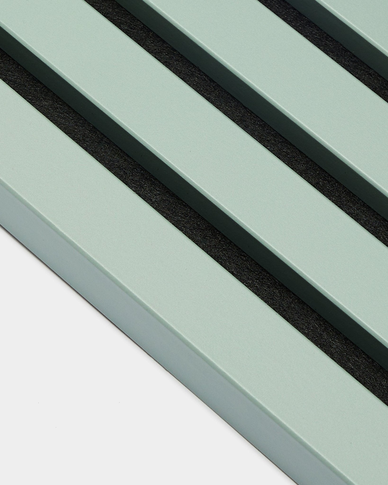 Close-up of three parallel pastel green End Lamella / Cloud slats, 2.2 cm wide, by WoodUpp, as part of an Akupanel acoustic panel against a light background.