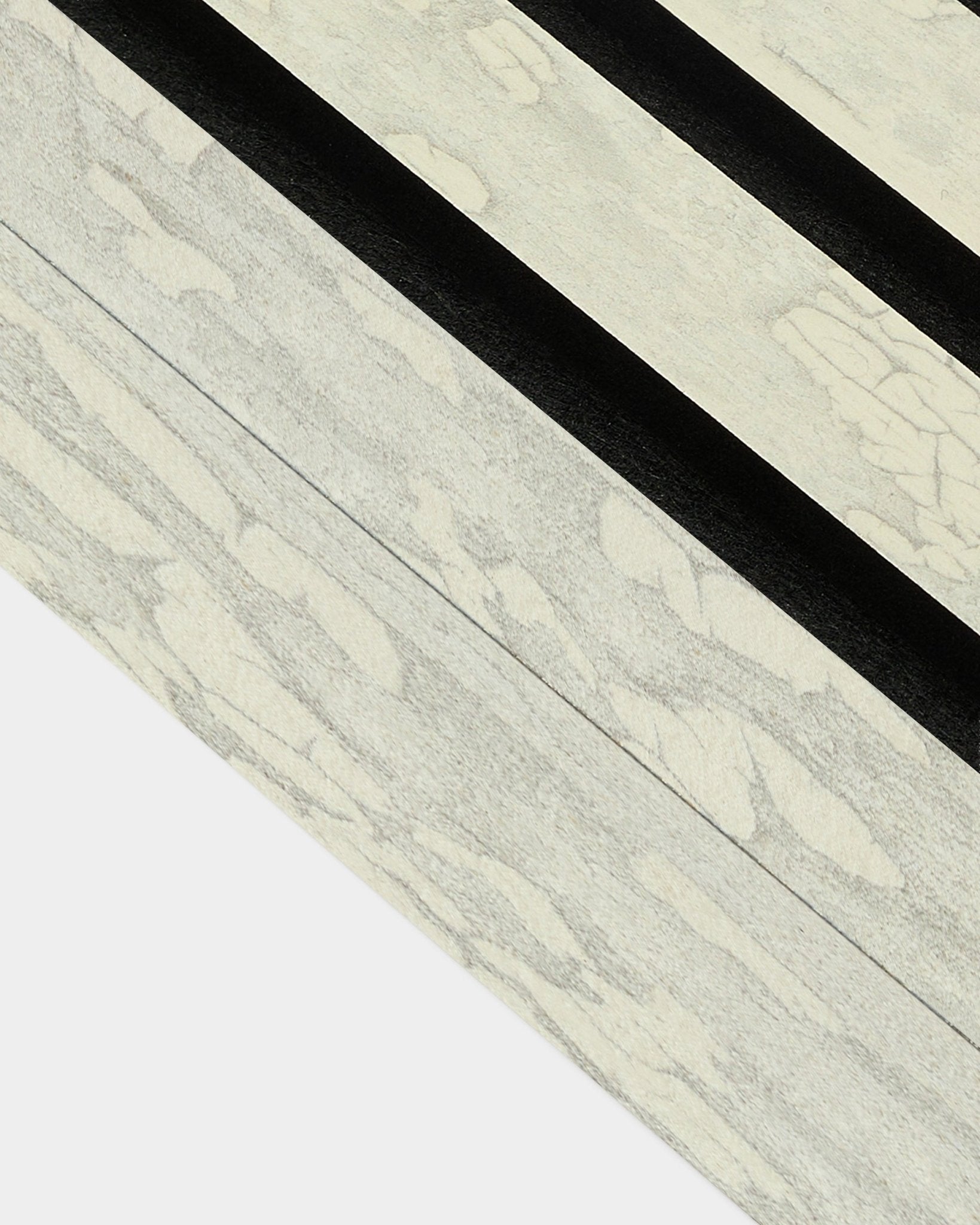 Nærbillede af Oxide White End Lamella (6,7 cm) fra WoodUpp til Akupanel-akustikpanelinstallation med dristige sorte diagonale mønstre i et nordisk design.