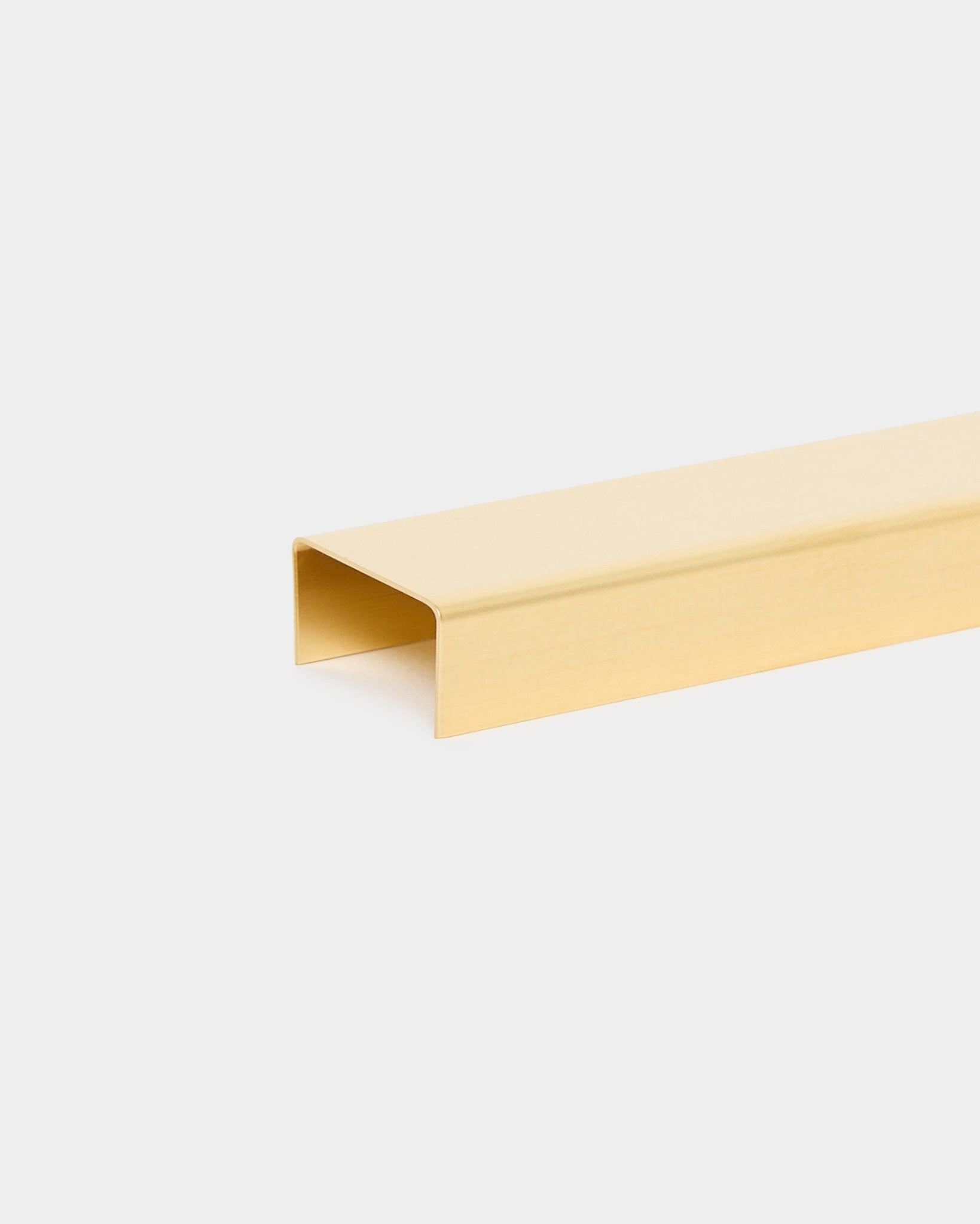 Liva | Cover / Brass, 120 cm fra WoodUpp er et U-formet metalkantsbeslag i guldtone til akustiske træpaneler, vist på en lys baggrund.