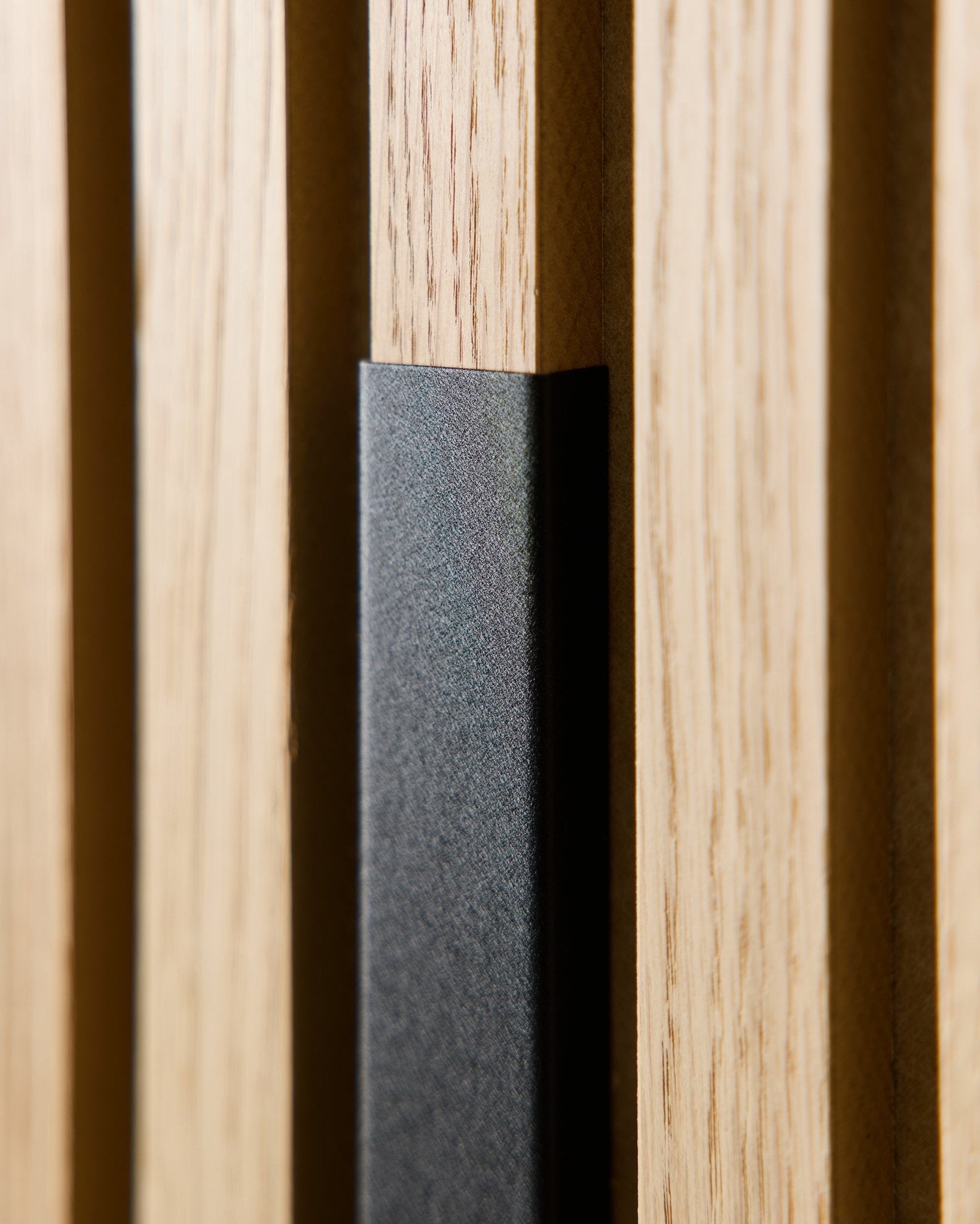 Nærbillede af WoodUpp Liva Akustikpanel med 60 cm black aluminiumscover, der viser vertical trælameller og en black detalje til moderne, nordiske interiører.