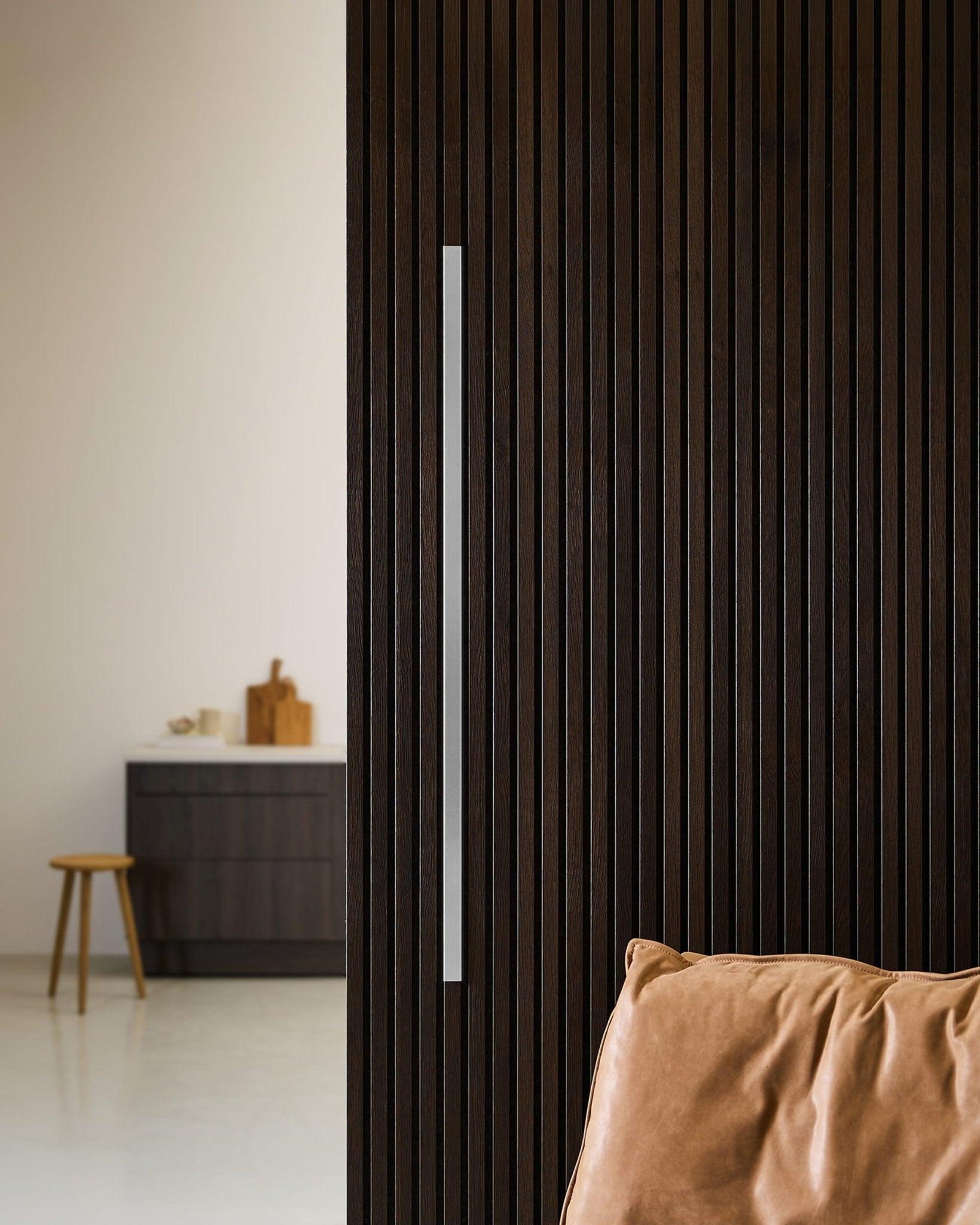 Akupanel-dør i mørkt træ med WoodUpp Liva Cover, 120 cm stålhåndtag, dekorativ kantliste, læderpude og minimalistisk nordisk køkken med skammel.