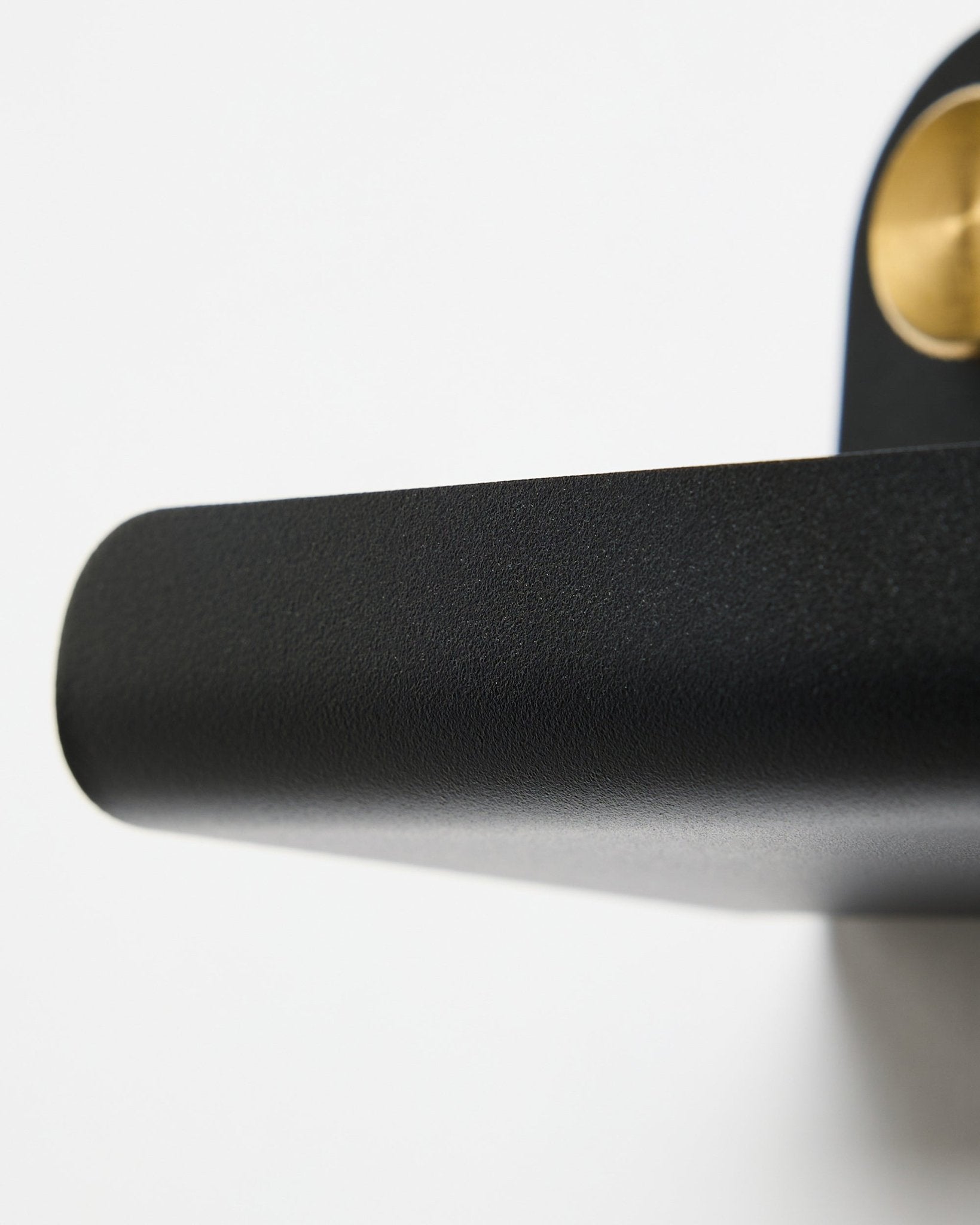 Nærbillede af et black dørhåndtag og WoodUpp Norr | Narrow Shelf i black, 51,9 cm, placeret mod en hvid baggrund.