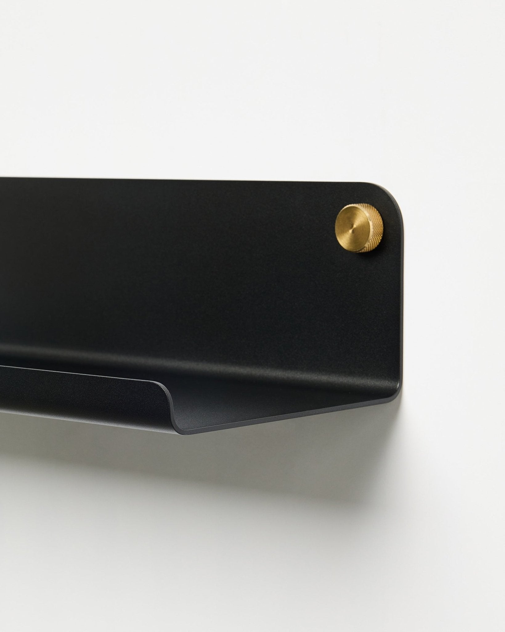 Nærbillede af tilbehøret WoodUpp Norr Wide Shelf (51,9 cm) i pulverlakeret black metal med gylden skrue, placeret mod en enkel hvid baggrund.