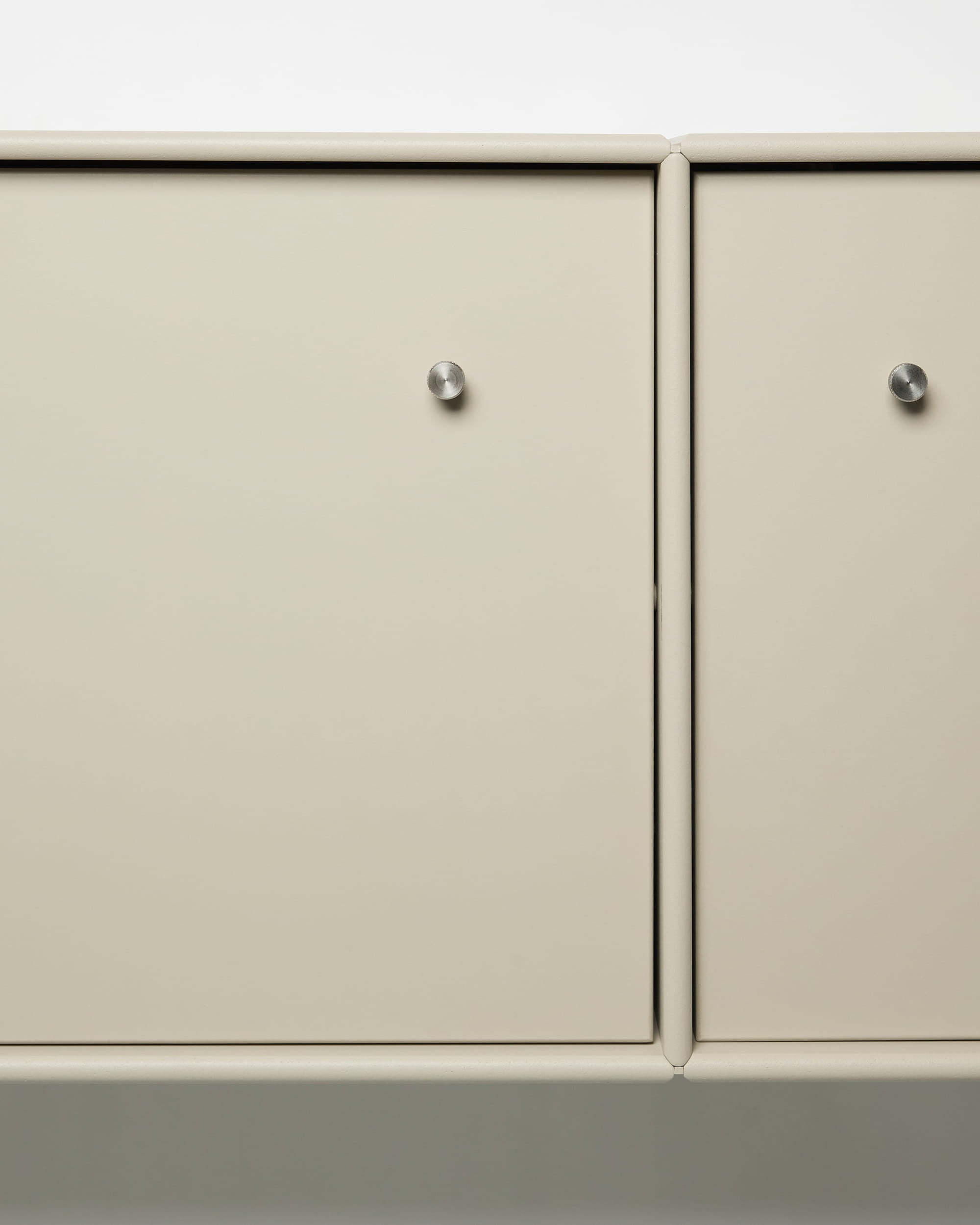 Arka TV-møbel fra WoodUpp med beige metaldøre, runde sølvknopper, modulært design og integreret kabelstyring, der passer perfekt til nordiske interiører.