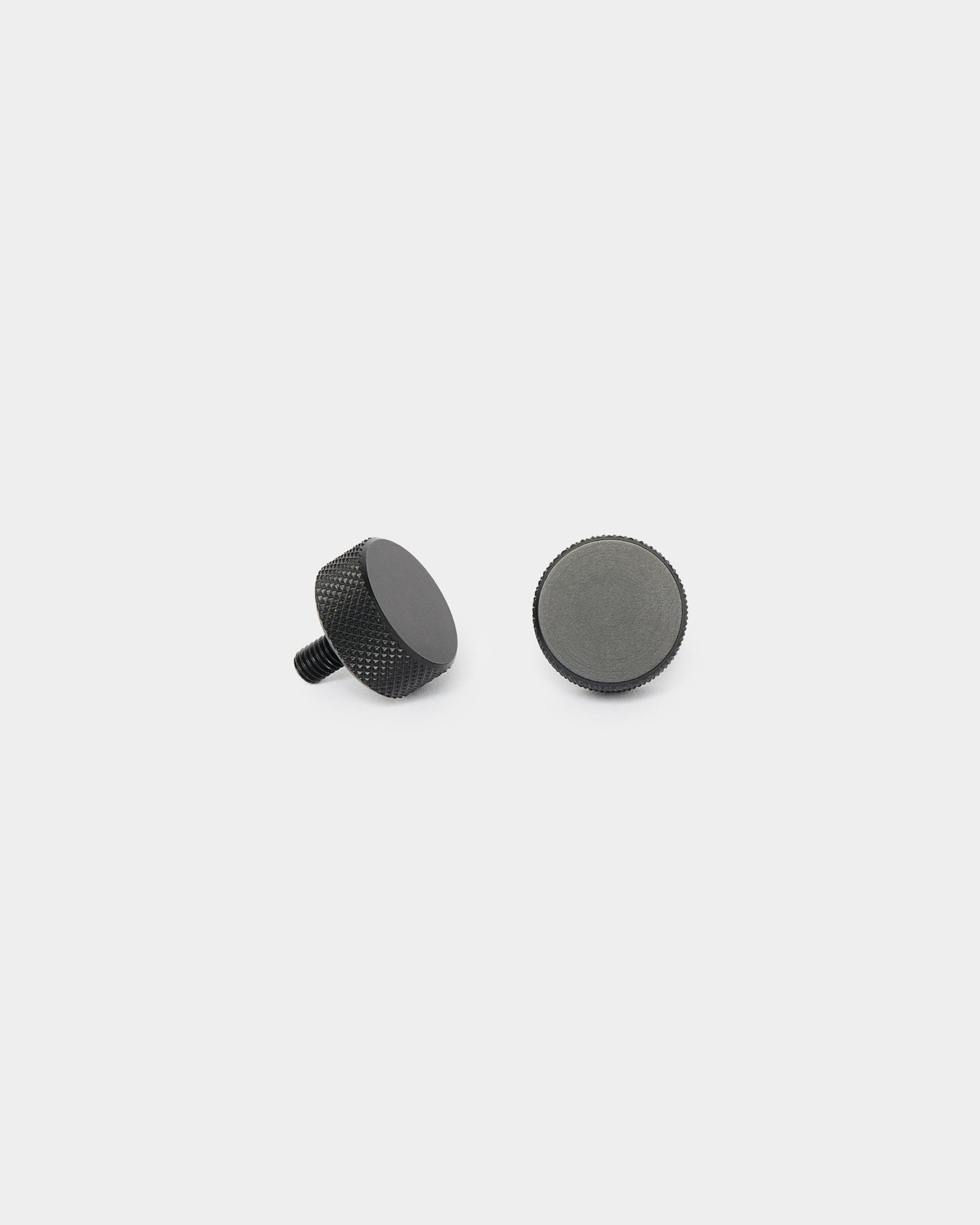 Two black WoodUpp Finger screws (2 pcs, M5x10mm, 20x8.8) displayed upright and lying on their side on a plain white background for Akupanel installation.