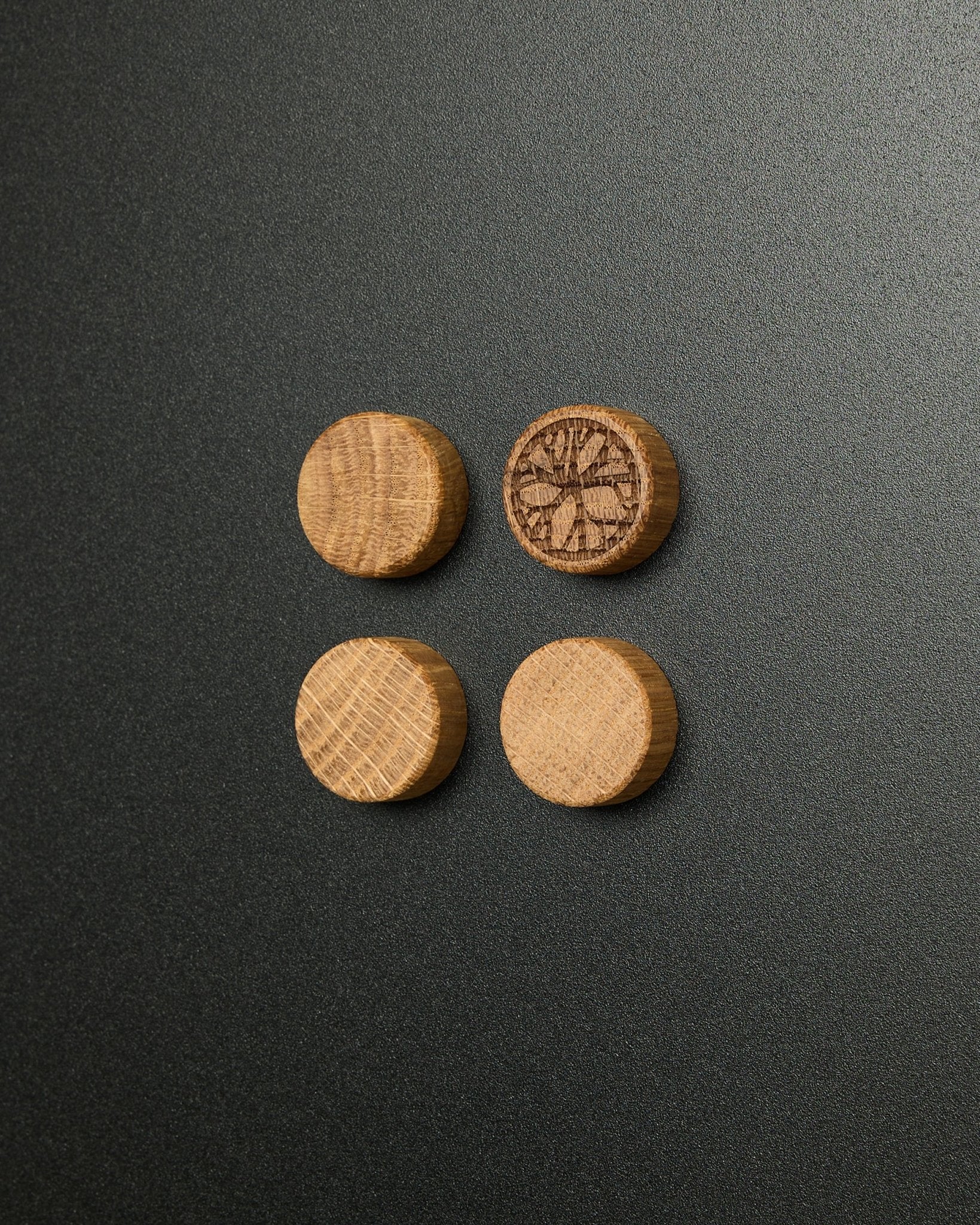 Sæt med fire massive natural oak magneter fra WoodUpp, hvor én har et udskåret citrusskive-design, designet til brug med Norr Magnetic Board Akustikpanel.