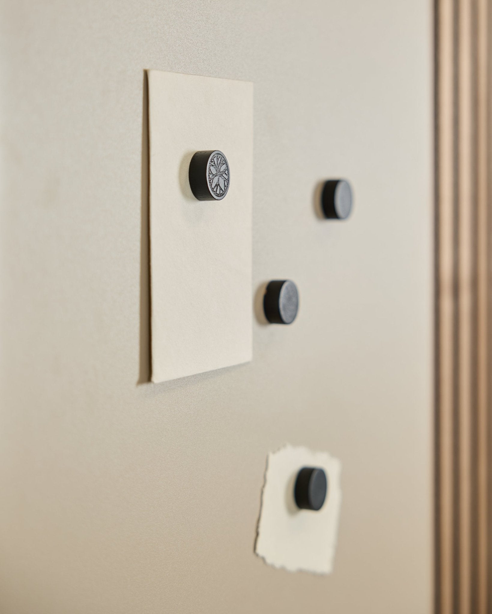 Fire WoodUpp Norr Magnet set i Black Oak (4 stk.) holder to ark fast på en Norr Magnetic Board, med en del af en Akustikpanel synlig til højre.