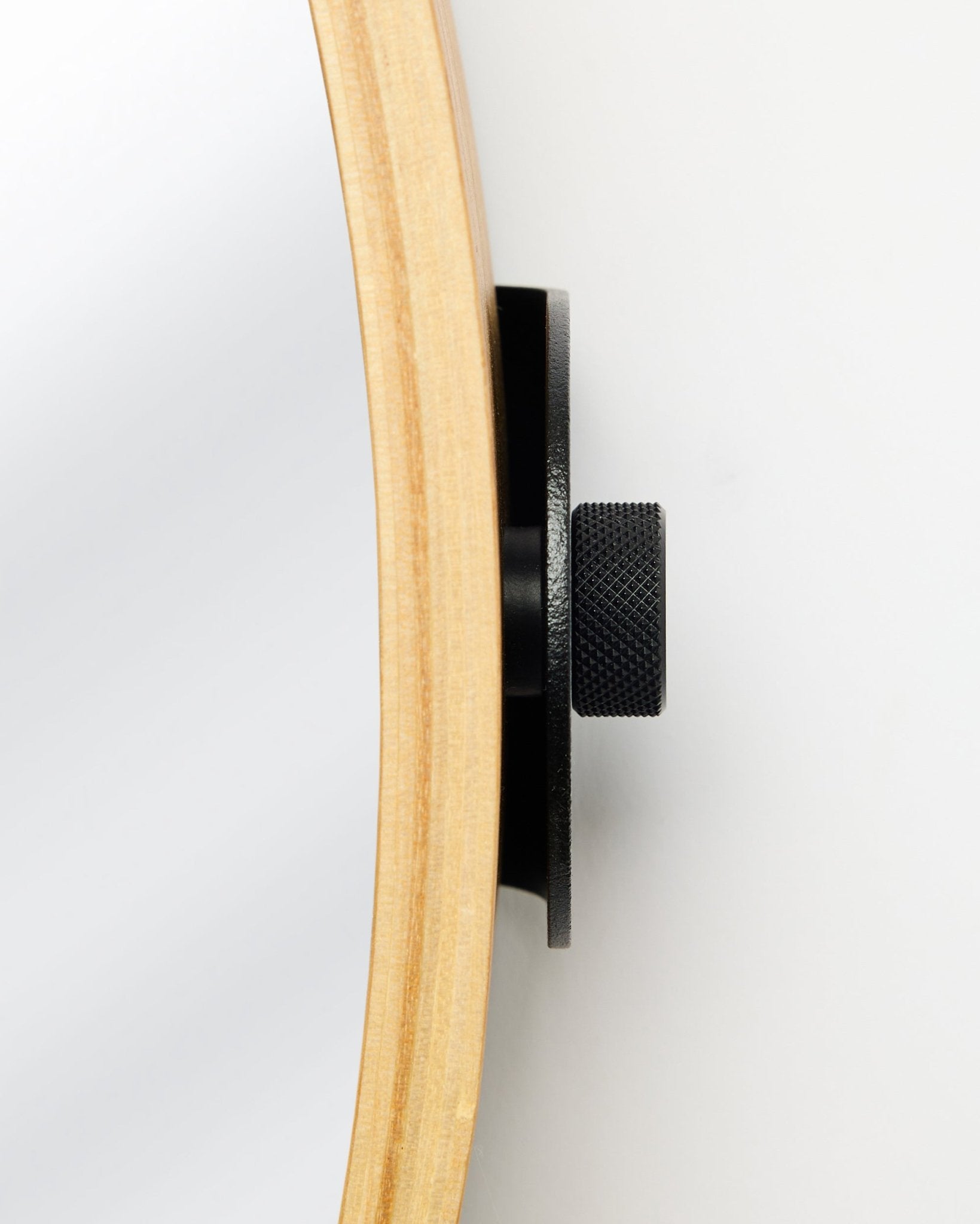 Nærbillede fra siden af WoodUpp Linn | Mirror i Natural Oak med en rund ramme i eg og knop i metal i black, et tilbehør til akustikpaneler i træ.