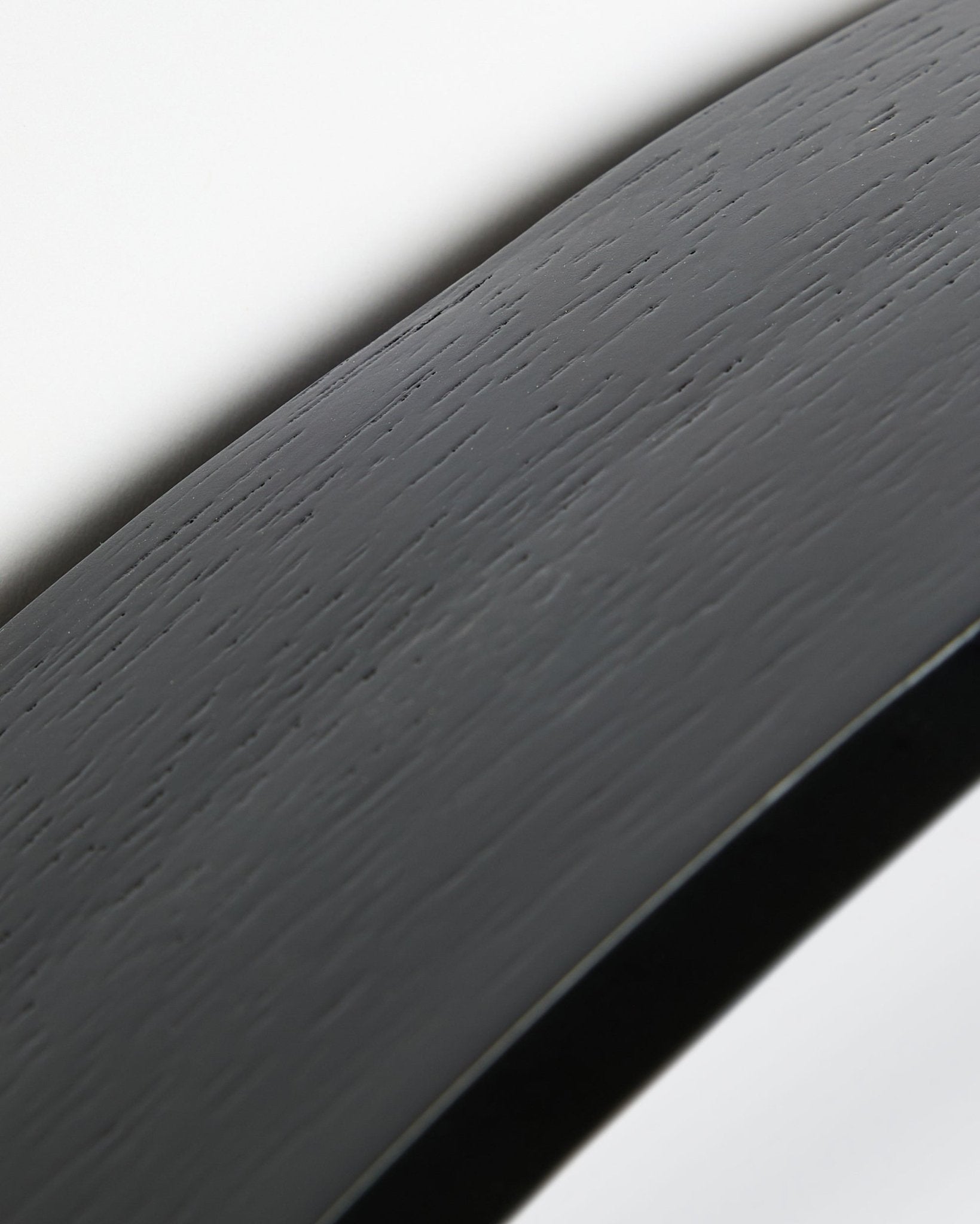 Nærbillede af Linn | Mirror / Black Oak Akustikpanel fra WoodUpp med en buet black oak overflade og ramme mod en hvid baggrund.