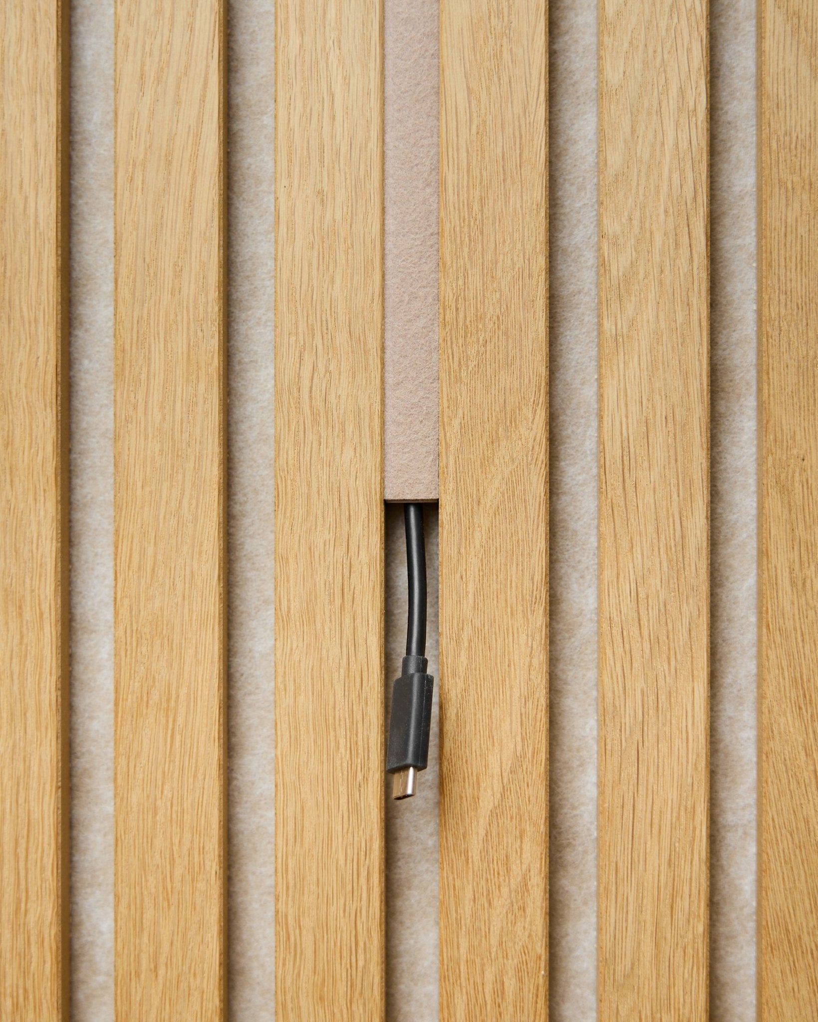 Dupps Pop-on Cable Cover (beige, sæt med 3) fra WoodUpp skjuler kabler mellem Akustikpanel lameller, så kun stikket er synligt og giver en enkel finish.