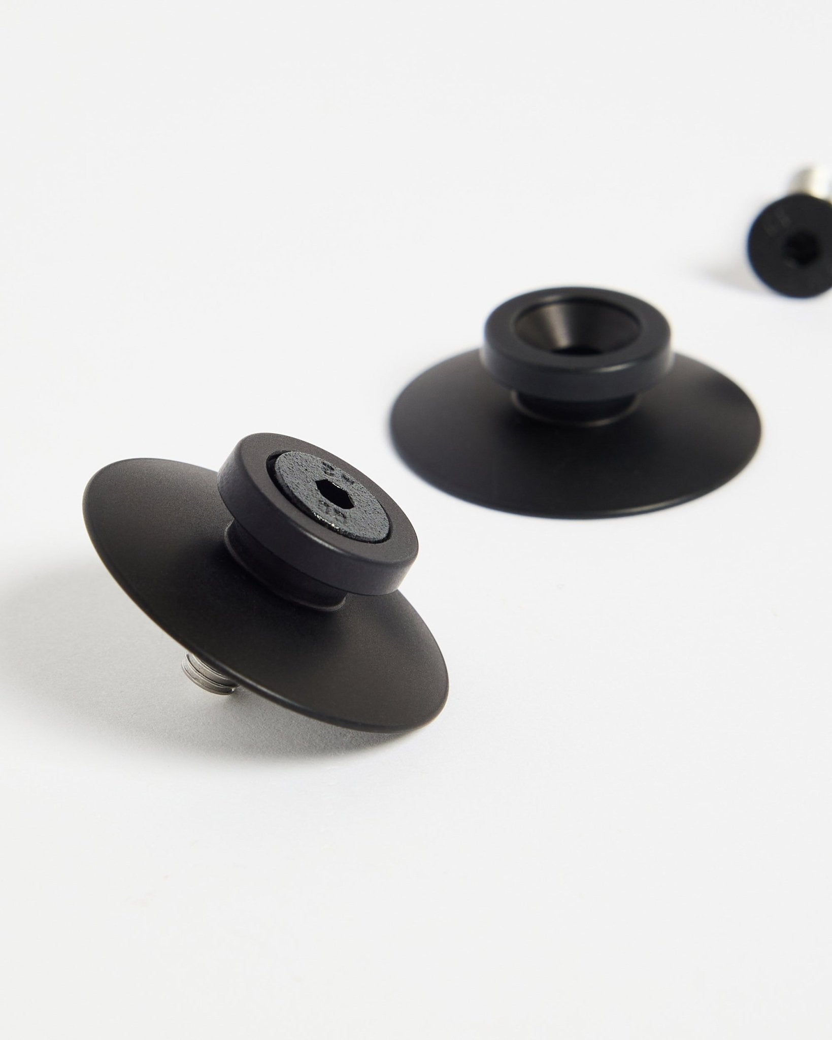To black aluminium Dupps monteringsbeslag fra WoodUpp (2 stk.) på en hvid overflade, designet til sikker montering af akustikpaneler eller rumdelere.