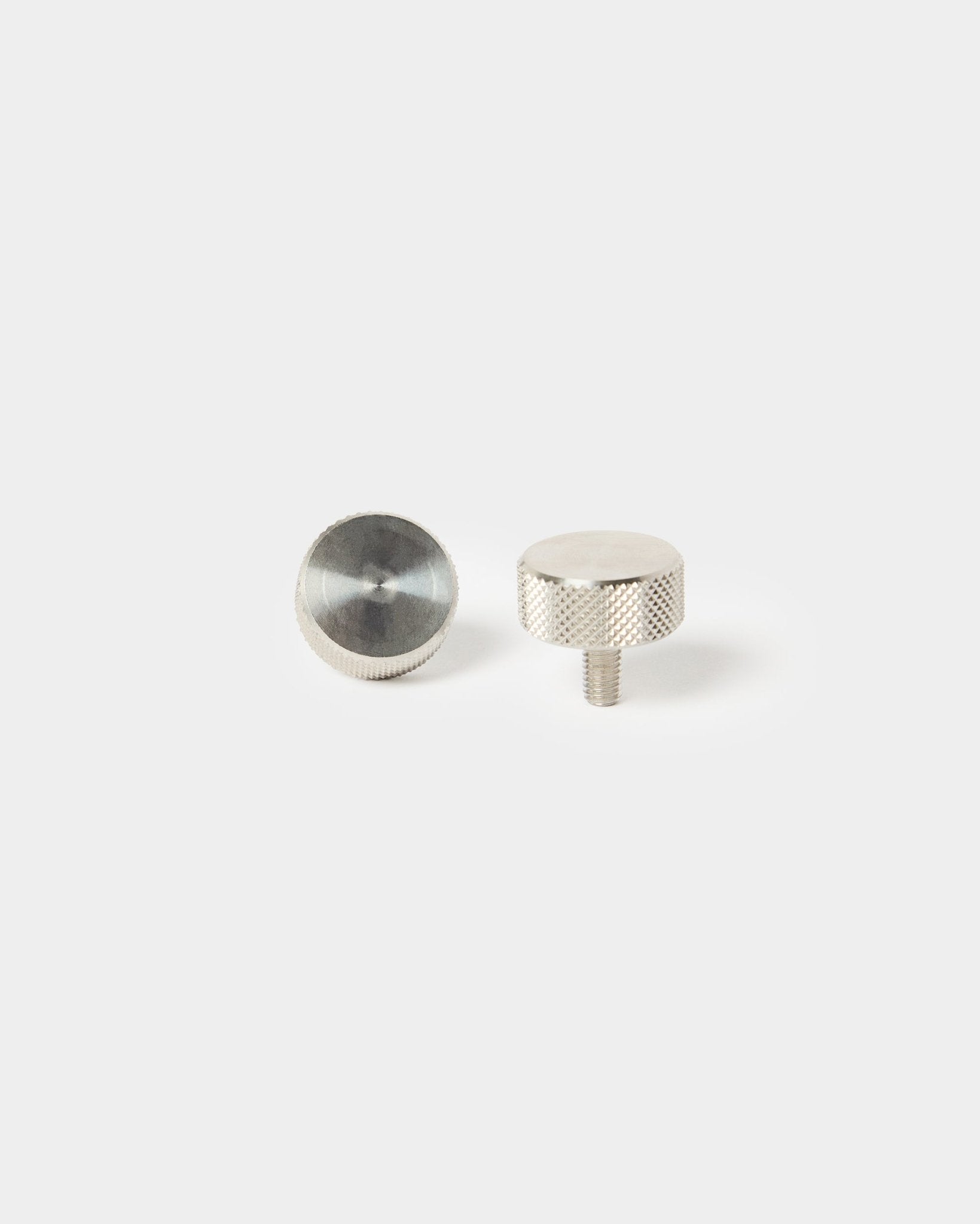Et par WoodUpp fingerskruer i rustfrit steel (M5x10 mm, 20x8.8) til montering af Akustikpanel – én med gevindende, én med glat top.
