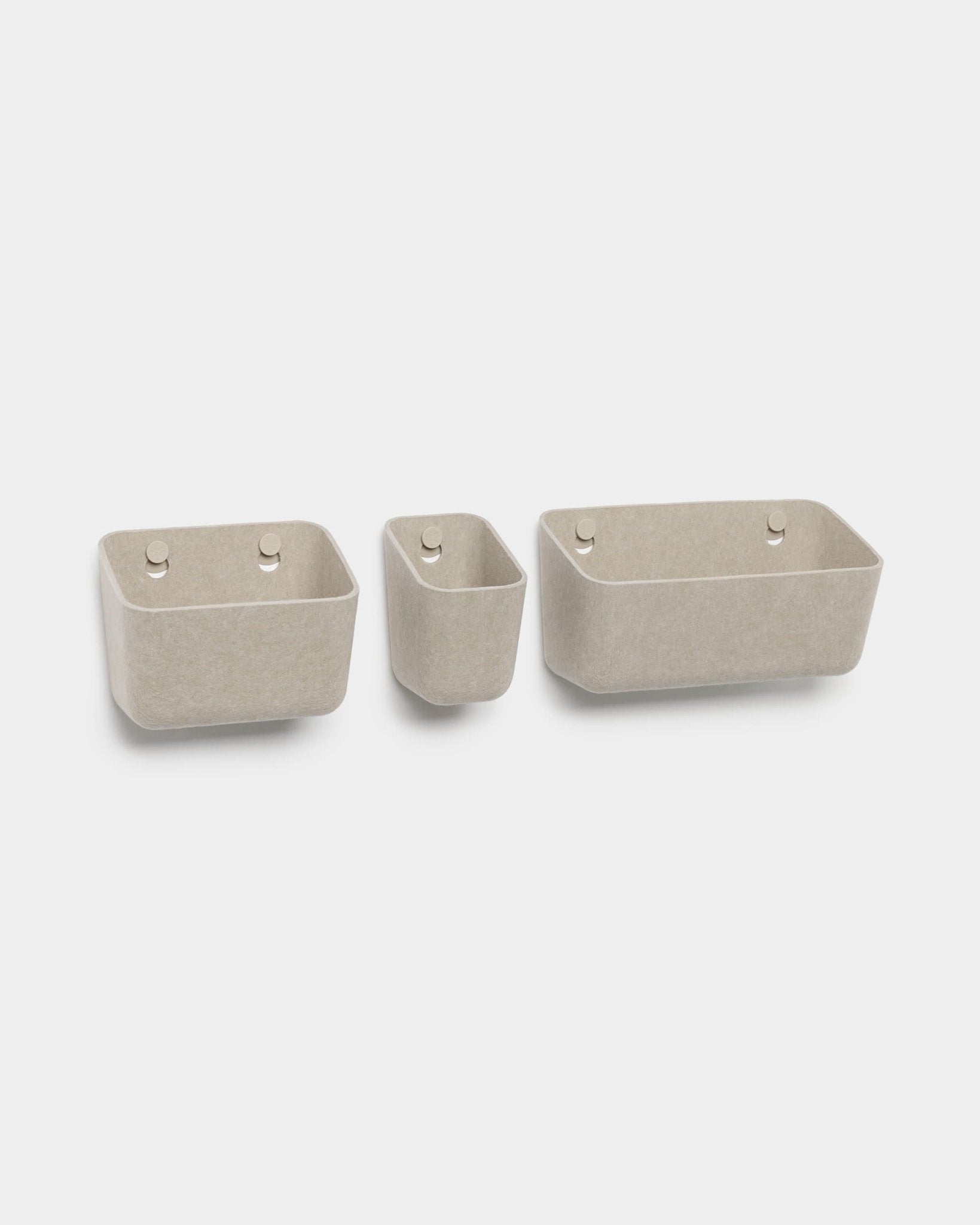 Sæt med tre beige WoodUpp Luva-filtbeholdere, hver med to runde ophængshuller, vist på hvid baggrund.