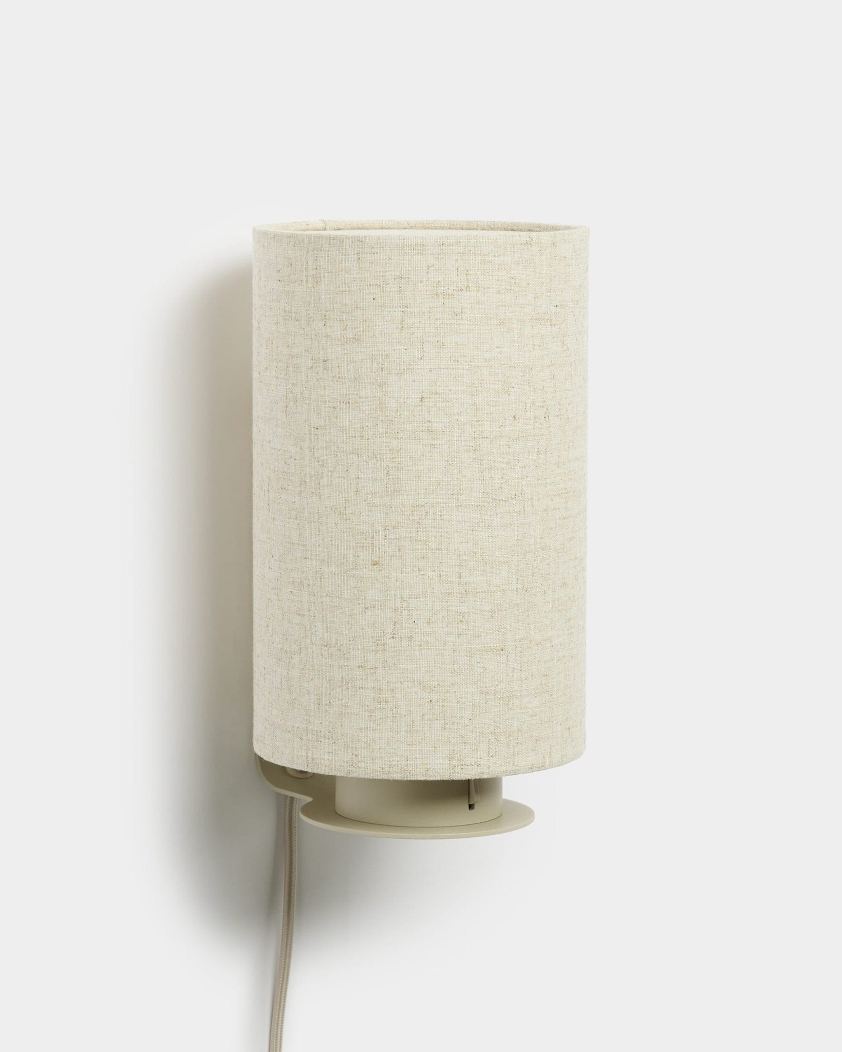Feya | Wall Lamp by WoodUpp with a cylindrical linen-cotton shade and visible white cord, beige finish, designed to complement acoustic wood panels.