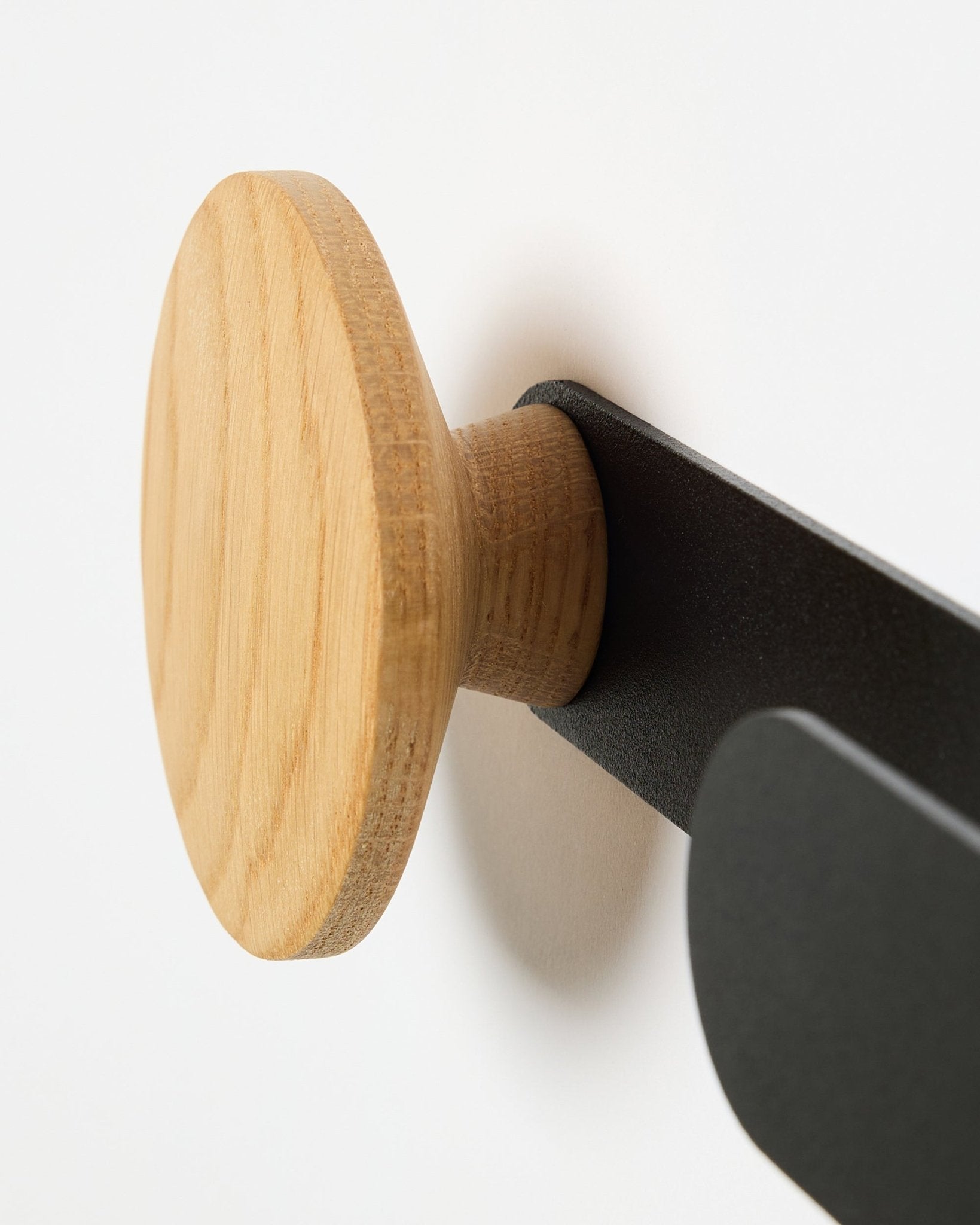 Nærbillede af WoodUpp Linn Horizontal Hanger i natural oak på et black metalbeslag, designet til Akupanel akustikpaneler eller som en funktionel vægkrog.