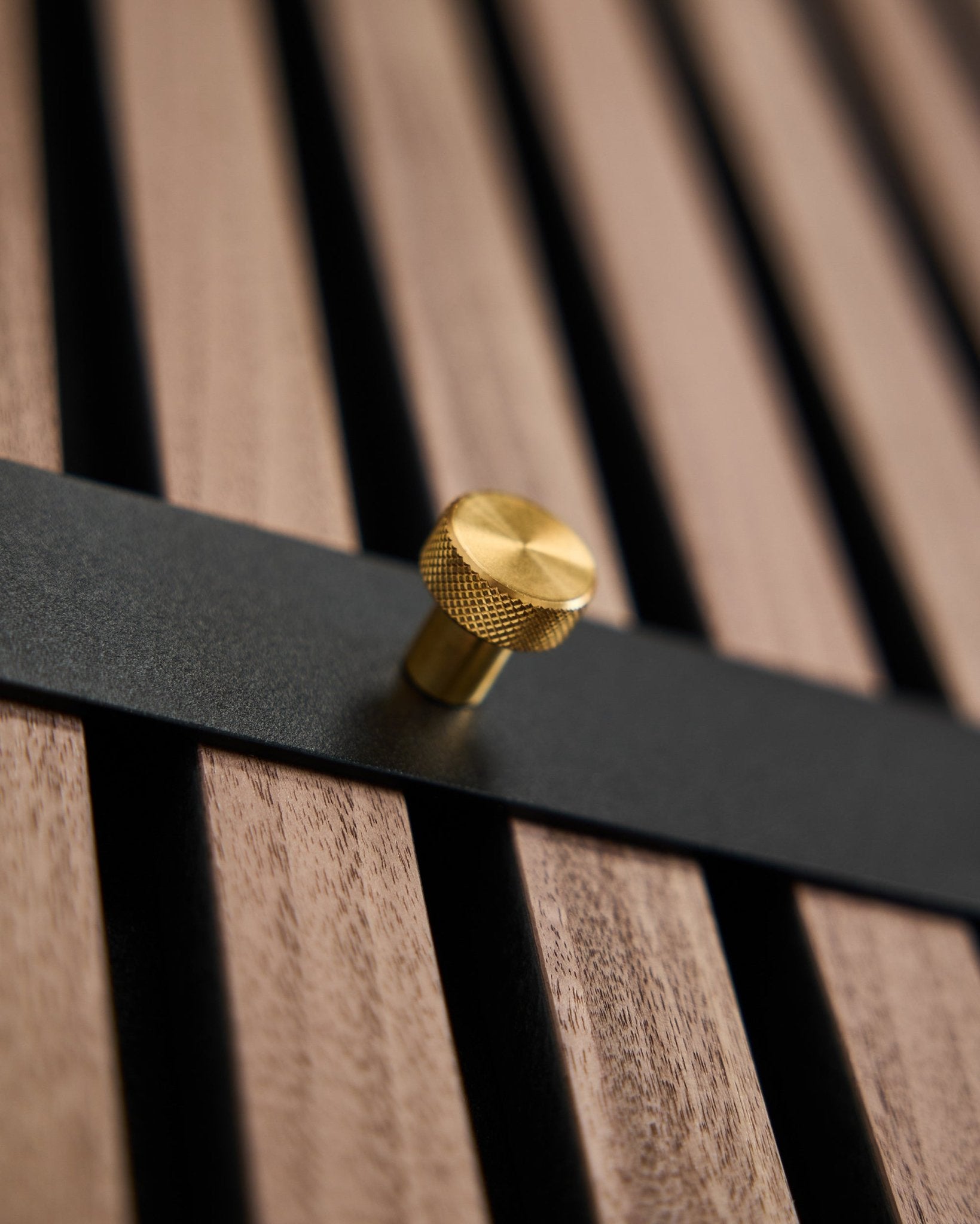 WoodUpp Norr knagerække har syv black kroge med brass knopper monteret på et brown akustikpanel med lameller, designet som et nordisk tilbehør til Akupanel.
