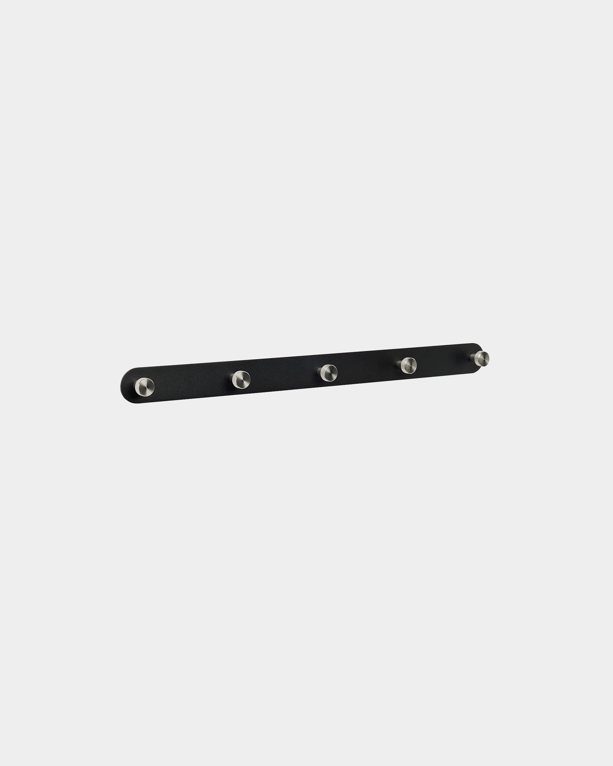 WoodUpp Norr Coat Hook Rack X5 i sort og rustfrit stål, med fem jævnt fordelte kroge, monteret på en almindelig hvid baggrund. Nordisk minimalistisk design.