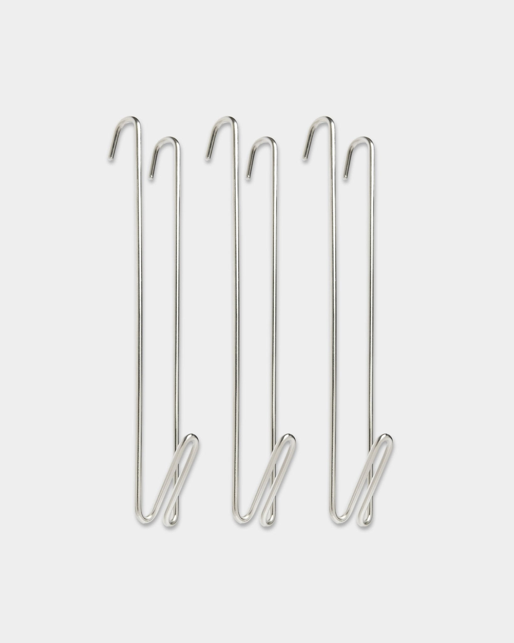 Three WoodUpp Alva stainless steel BM1 wire hook closet rod extenders, designed to add additional hanging space alongside acoustic wood panels.