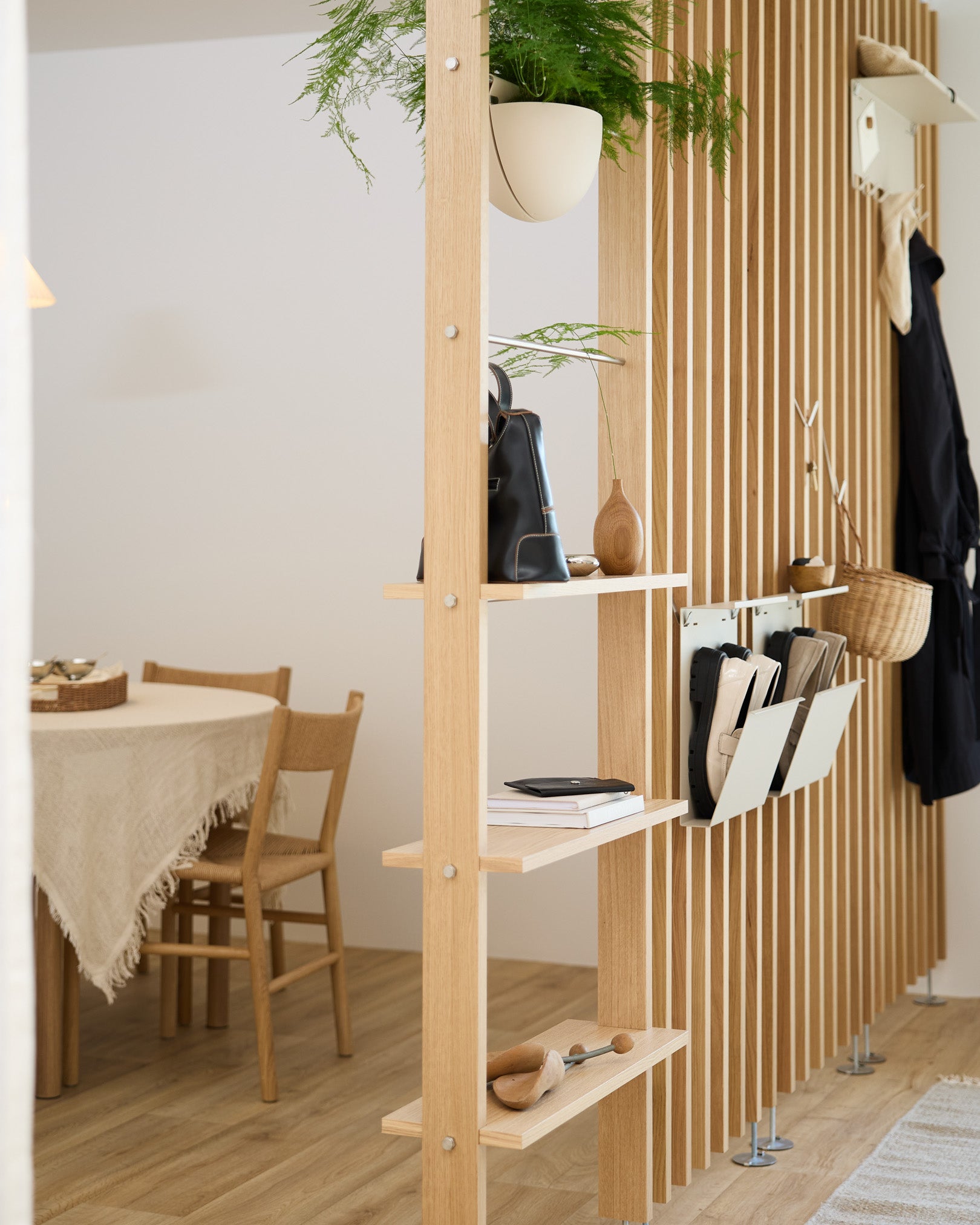 Åbne træhylder opdeler spisepladsen med Nell Shoe Storage i beige fra WoodUpp, som giver god plads til skoene i et moderne nordisk hjem.