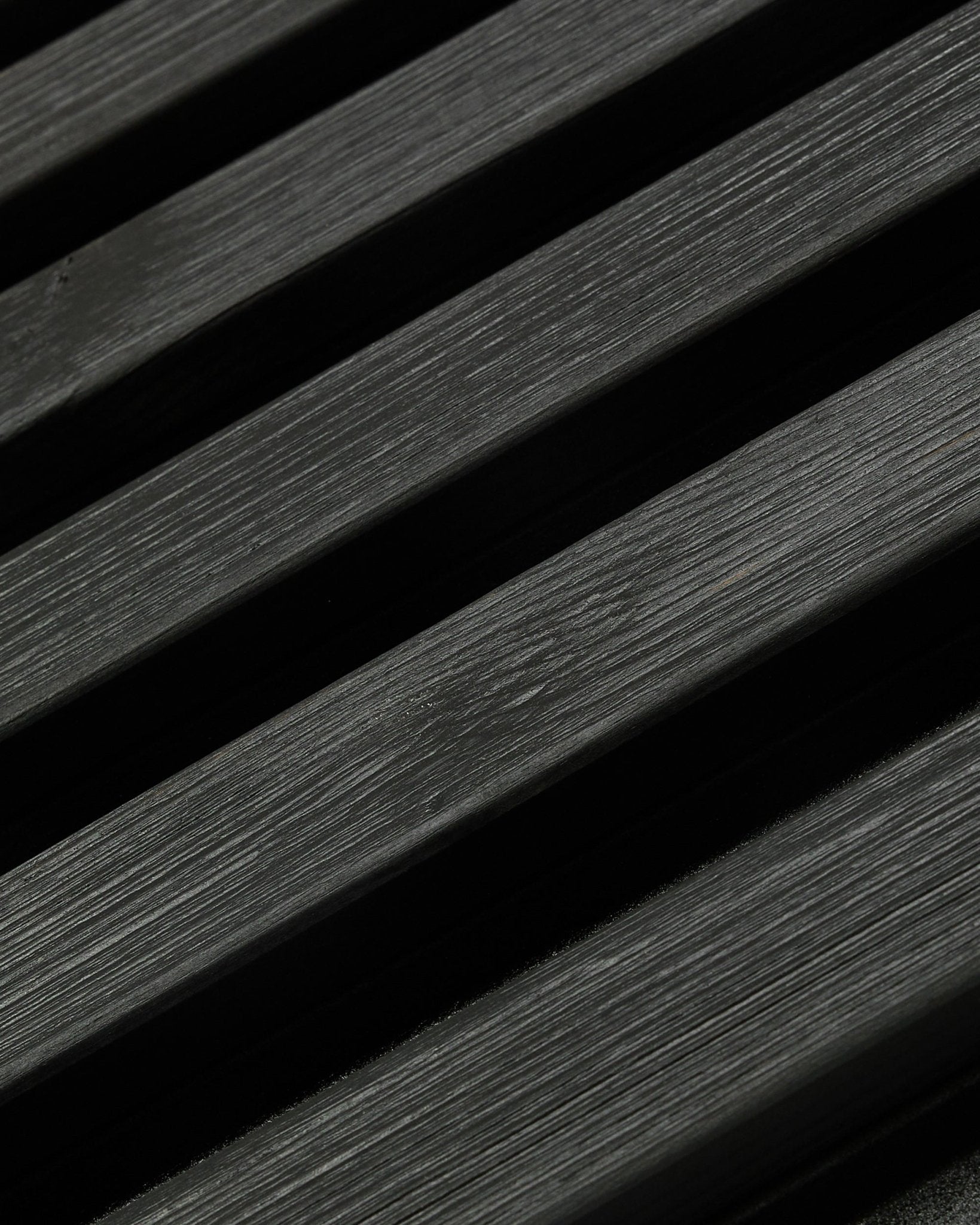 Aluwood udendørs facadepanel fra WoodUpp, Thermowood i black finish, 240 x 45,1 cm, med diagonale lameller i nordisk gran med synlig åretegning og skygge.