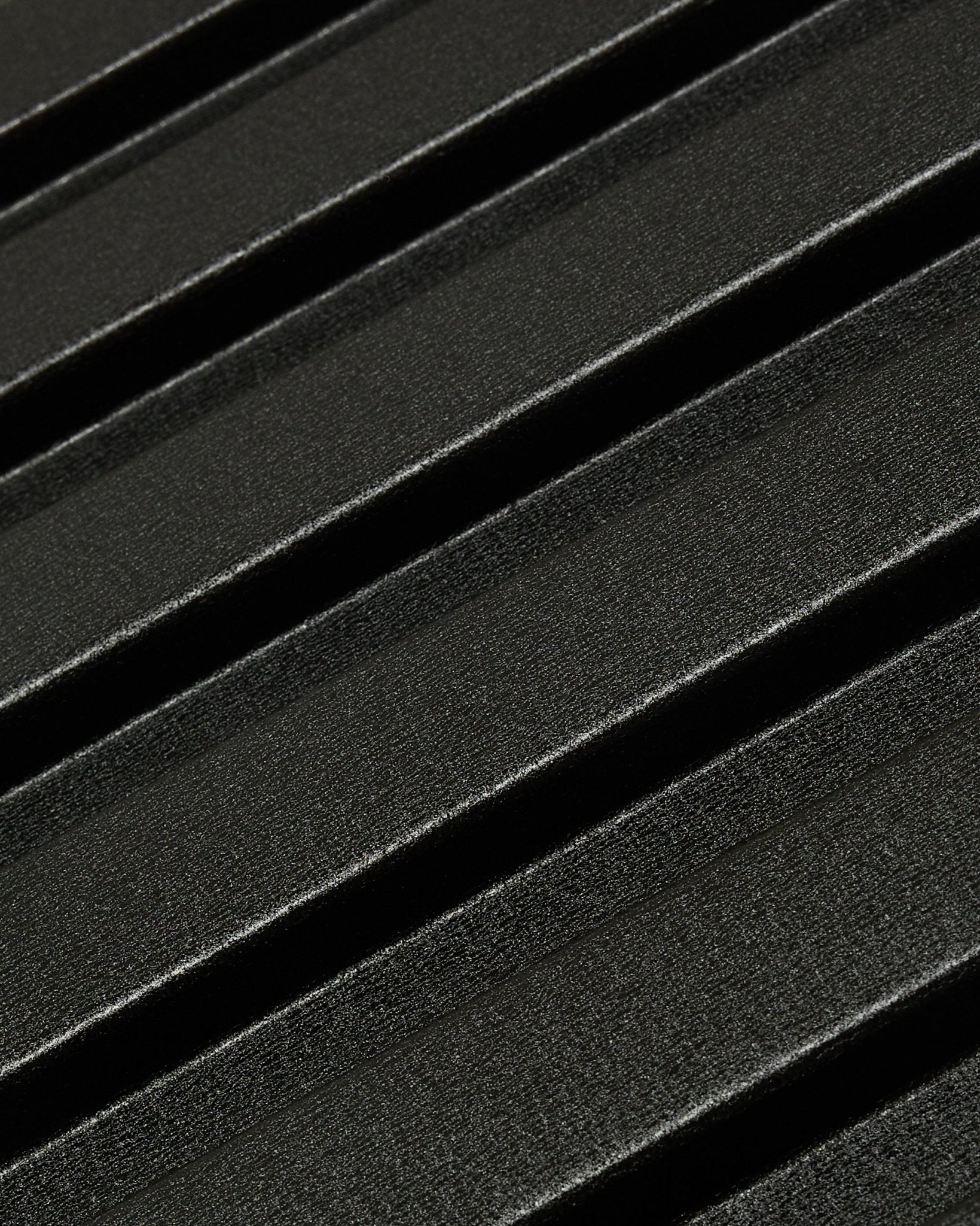 Nærbillede af Aluwood udendørs facadepanel fra WoodUpp: mørk, tekstureret overflade i genanvendt aluminium med diagonale ophøjede riller, måler 240 x 45,1 cm.