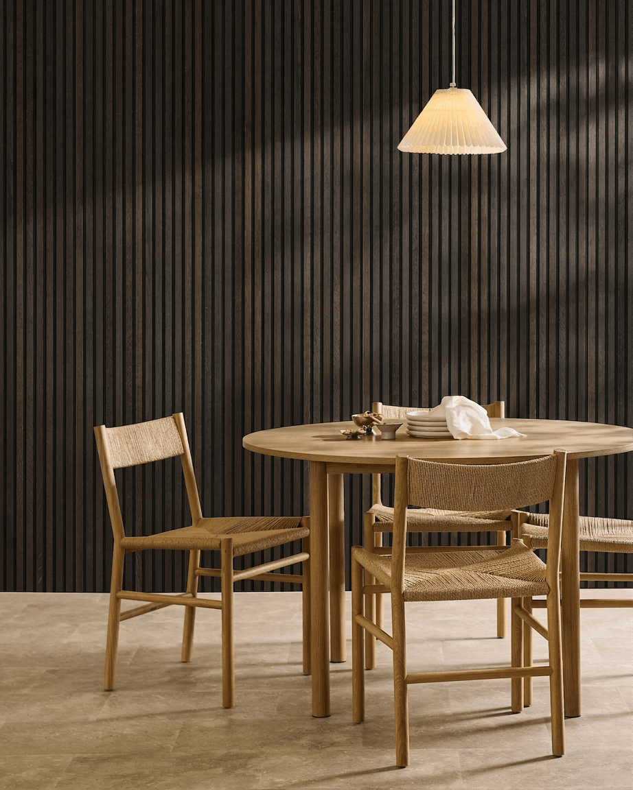 Minimalistisk spiseområde med et træbord, skandinaviske stole, pendellampe og et WoodUpp Akupanel Rustic Smoked Oak akustisk lamelvægspanel.