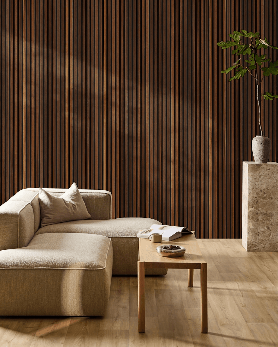 Minimalistisk stue med en beige sofa, sofabord med en åben bog, høj plante og WoodUpp Akupanel akustiktræpanel i røget lærk på væggen.