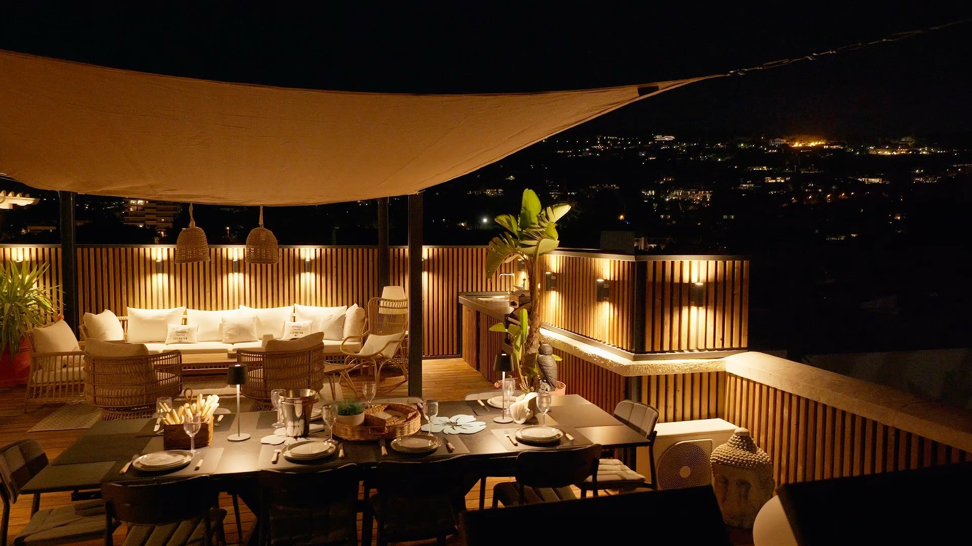 Aluwood aluminium slat cladding lit by warm wall lights on a rooftop terrace balcony at night