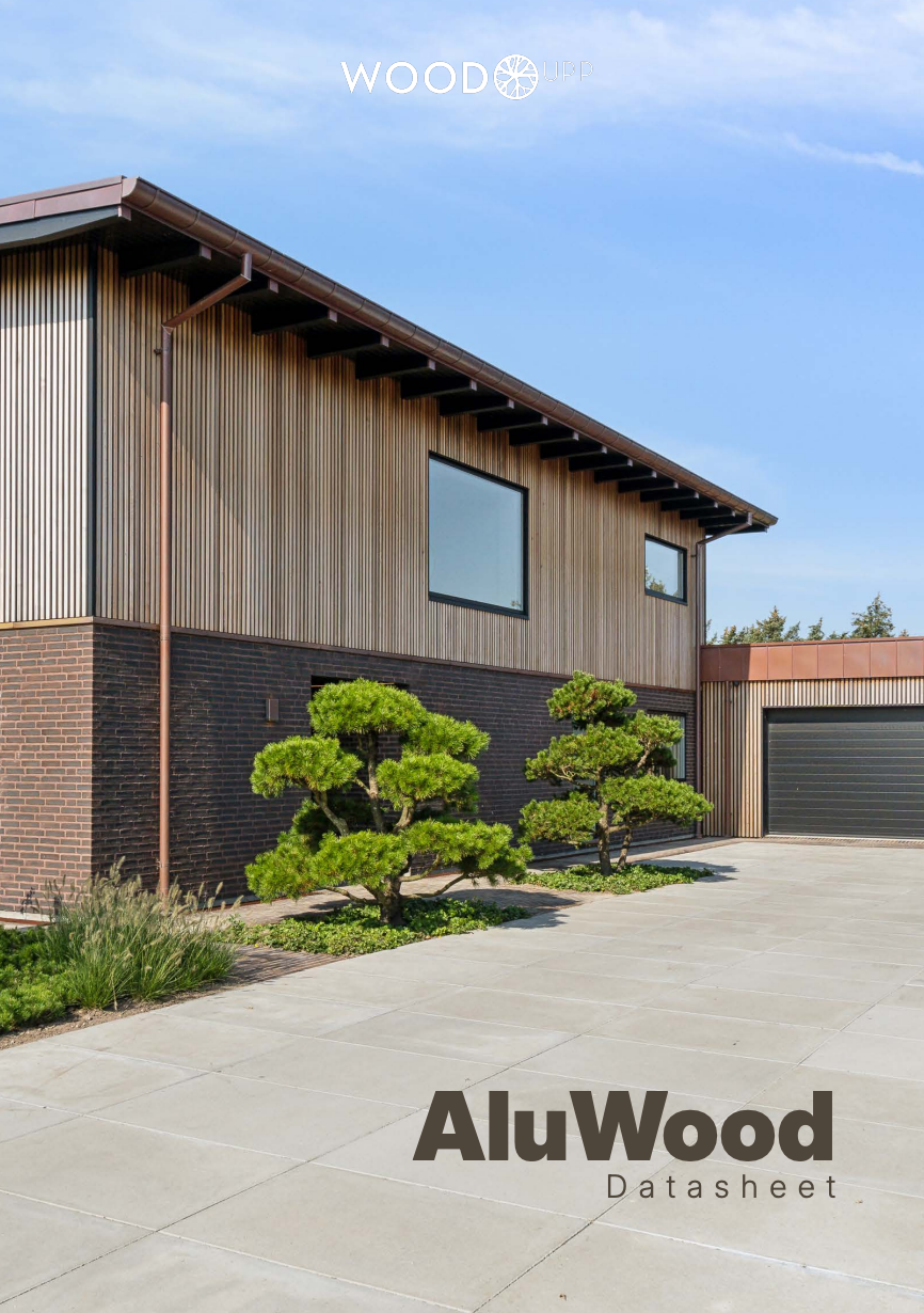 Moderne hus med AluWood-facadepaneler og mursten udvendigt, med store vinduer, garage og velplejet landskab. Teksten lyder på AluWood-datablad.